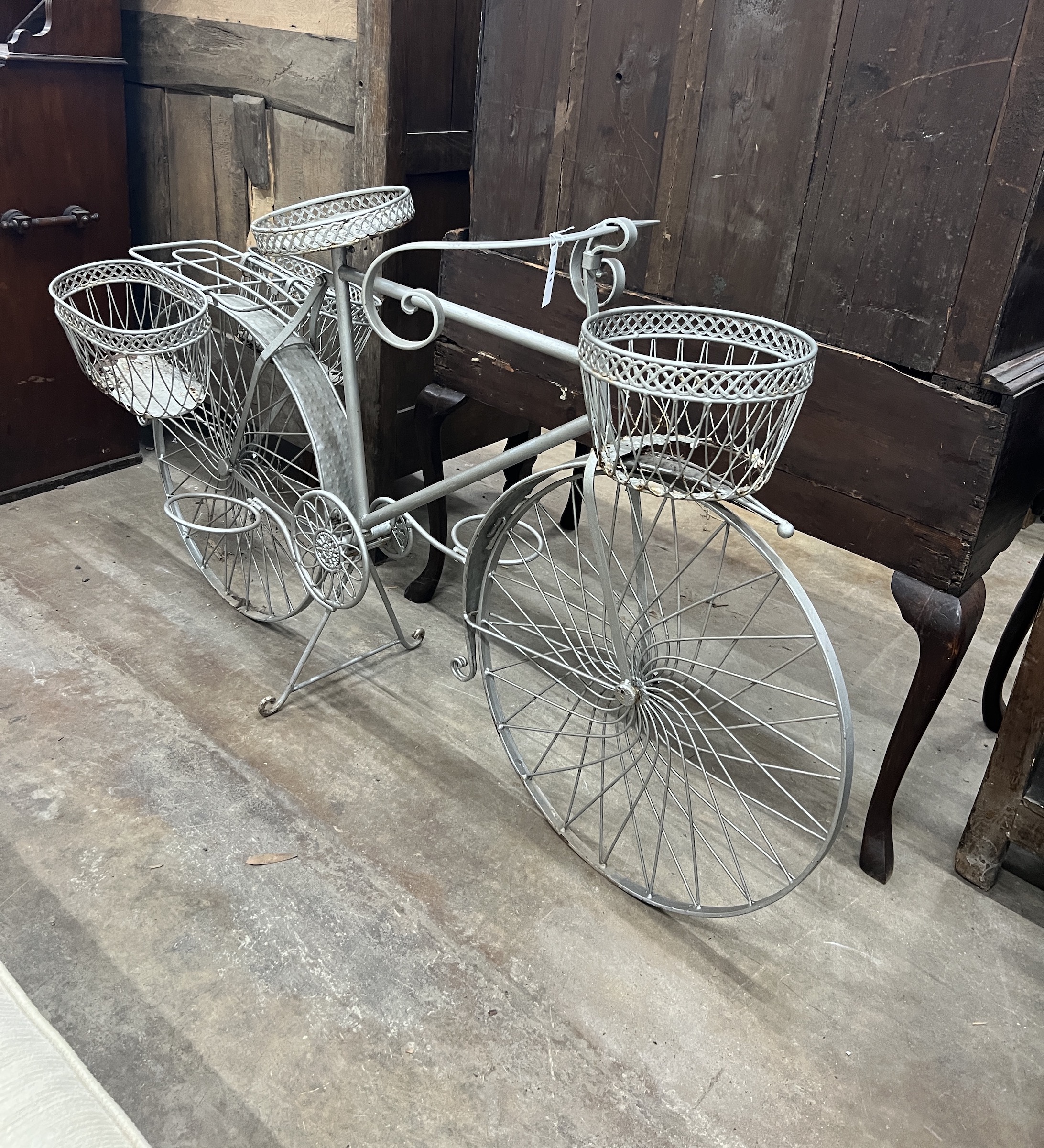 A wrought metal ' Bicycle' garden pot stand, length 144cm, height 90cm